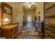 A long hallway featuring hardwood floors, vintage furniture, and interesting area rugs at 3011 Broughton Rd, Newborn, GA 30056