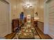 Hallway with hardwood floors, vintage cabinets, and patterned area rug at 3011 Broughton Rd, Newborn, GA 30056