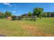 Open grassy land featuring a vintage fenced enclosure and charming buildings under a clear sky, great for outdoor enjoyment at 3011 Broughton Rd, Newborn, GA 30056