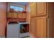 Functional laundry room featuring a side-by-side washer and dryer and ample storage space within light wood cabinets at 3011 Broughton Rd, Newborn, GA 30056