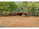 An open-sided shed surrounded by trees offering ample outdoor storage at 3011 Broughton Rd, Newborn, GA 30056