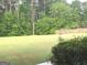 Large grassy backyard with a wood fence and mature trees providing ample privacy at 6279 Giles Rd, Lithonia, GA 30058
