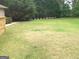 Expansive backyard featuring lush green grass and mature trees, a perfect space for outdoor activities at 6279 Giles Rd, Lithonia, GA 30058