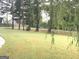 Spacious backyard with mature trees and a view of a quiet street at 6279 Giles Rd, Lithonia, GA 30058