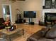 Cozy living room with fireplace, hardwood floors, and large TV at 6279 Giles Rd, Lithonia, GA 30058