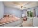 A bright bedroom featuring a large window and a bed with pink accents at 205 Olde Oak Dr, Jonesboro, GA 30238
