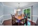 Elegant dining room with hardwood floors, wainscoting, and large window with lush greenery at 205 Olde Oak Dr, Jonesboro, GA 30238