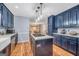 Beautiful kitchen with blue cabinets, granite countertops, an island with a cooktop, and stainless appliances at 205 Olde Oak Dr, Jonesboro, GA 30238