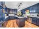 Stylish kitchen boasts navy cabinets, granite countertops, stainless steel appliances, and center island at 205 Olde Oak Dr, Jonesboro, GA 30238