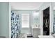 Bathroom featuring a single sink vanity, floral shower curtain, and neutral tile floor at 321 Harris Ave, Locust Grove, GA 30248