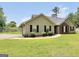 Inviting single-story home featuring a lush lawn, neatly trimmed shrubs, and a paved walkway to the entrance at 321 Harris Ave, Locust Grove, GA 30248