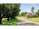 Charming single-story home with a long driveway, green lawn, and mature trees providing ample shade at 321 Harris Ave, Locust Grove, GA 30248
