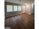Cozy living room featuring sleek hardwood floors, neutral paint, three windows and a front entry door at 7560 Taylor Rd # 1, Riverdale, GA 30274