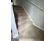 A carpeted staircase ascends, featuring a white handrail against a gray wall, providing a safe and stylish transition between floors at 7560 Taylor Rd # 1, Riverdale, GA 30274