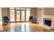 Bright living room featuring hardwood floors, a fireplace, and french doors leading to a deck at 1622 Brentwood Se Xing, Conyers, GA 30013