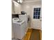 Well-lit laundry room features modern washer and dryer and plenty of cabinet space at 107 Rolling Grn, Peachtree City, GA 30269