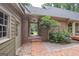 Exterior shot of a backyard entrance featuring a covered porch, brickwork, and garden at 107 Rolling Grn, Peachtree City, GA 30269
