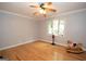 Inviting bedroom featuring hardwood floors, a ceiling fan, and natural light, creating a warm and serene environment at 107 Rolling Grn, Peachtree City, GA 30269