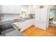 Bright kitchen featuring white cabinets, grey countertops, stainless steel appliances, and hardwood floors at 107 Rolling Grn, Peachtree City, GA 30269