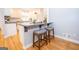 Bright kitchen bar with seating features modern accents and hardwood floors at 107 Rolling Grn, Peachtree City, GA 30269