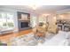 Open-concept living room features hardwood floors, a fireplace, and access to a wooden deck at 107 Rolling Grn, Peachtree City, GA 30269