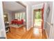 Inviting living room featuring hardwood floors, bright windows with white shutters, and a red front door at 107 Rolling Grn, Peachtree City, GA 30269