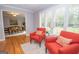 Comfortable living room boasts hardwood floors, bright windows with white shutters, and comfortable orange seating at 107 Rolling Grn, Peachtree City, GA 30269