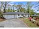 Charming white painted brick home with attached garage and lush flowering bushes in the front yard at 2694 Benjamin E Mays Sw Dr, Atlanta, GA 30311