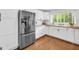 Bright kitchen features white cabinets, stainless steel fridge, wood counters, and a window overlooking the yard at 2694 Benjamin E Mays Sw Dr, Atlanta, GA 30311