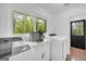 Spacious laundry room with a window providing backyard views, complete with modern washer and dryer at 2694 Benjamin E Mays Sw Dr, Atlanta, GA 30311