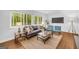 Bright living room with large windows, stylish furniture, and a cozy rug on hardwood floors at 2694 Benjamin E Mays Sw Dr, Atlanta, GA 30311