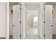 Hallway view to ensuite bathroom features plush carpet and walk-in closet with wire shelving at 1704 Goodwin Dr, Hampton, GA 30228