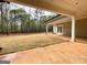 An expansive covered patio complements the property's outdoor space with a view of the green lawn and forest at 4585 Parkwood Rd, Social Circle, GA 30025