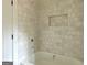 Bathroom showcasing a tiled shower and tub with recessed wall niche for storage at 4585 Parkwood Rd, Social Circle, GA 30025