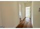 An interior hallway boasts wood flooring, leading to sunlit rooms and modern upgrades at 4585 Parkwood Rd, Social Circle, GA 30025