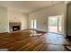 Spacious living room with hardwood floors, brick fireplace, and French doors to the yard at 4585 Parkwood Rd, Social Circle, GA 30025