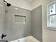 Modern bathroom with gray tiled walls and bathtub at 4601 Parkwood Rd, Social Circle, GA 30025