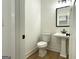 Half bathroom features toilet and pedestal sink at 4601 Parkwood Rd, Social Circle, GA 30025