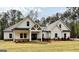 Charming new construction home featuring white siding, a welcoming porch, and professionally landscaped yard at 4601 Parkwood Rd, Social Circle, GA 30025