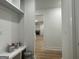 Hallway with white walls, baseboards, and doorframes offers views to the brick fireplace at 4601 Parkwood Rd, Social Circle, GA 30025