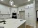 Modern kitchen boasts white cabinets, a large island with marble countertop, and stainless steel appliances at 4601 Parkwood Rd, Social Circle, GA 30025