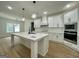 Modern kitchen features a large island with marble countertop, white cabinets, and stainless steel appliances at 4601 Parkwood Rd, Social Circle, GA 30025