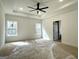 Main bedroom featuring bright windows, tray ceiling, and neutral carpet at 4601 Parkwood Rd, Social Circle, GA 30025