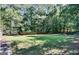 Spacious backyard with lush greenery, enclosed by a classic wooden fence, and shaded by towering trees at 1090 Crown River Pkwy, Mcdonough, GA 30252