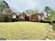 Charming brick home with a lush green lawn and mature trees at 1090 Crown River Pkwy, Mcdonough, GA 30252