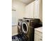 Well-lit laundry room featuring a modern washer and dryer set and ample storage cabinets at 1090 Crown River Pkwy, Mcdonough, GA 30252