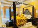 Spacious main bedroom with a dark wood four poster bed and neutral carpeting at 1090 Crown River Pkwy, Mcdonough, GA 30252