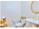 Traditional powder room with a toilet, sink, gold fixtures and decorative mirror at 1090 Crown River Pkwy, Mcdonough, GA 30252