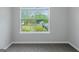 Bright bedroom featuring neutral paint, gray carpet, and a window view of the outdoors at 100 Hugh Dr, Covington, GA 30016