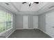 Bright primary bedroom featuring tray ceilings, multiple closets, and a large window at 100 Hugh Dr, Covington, GA 30016